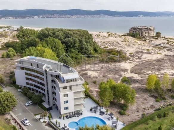 Bright living room with dining table and large windows in Sunny Beach apartment.