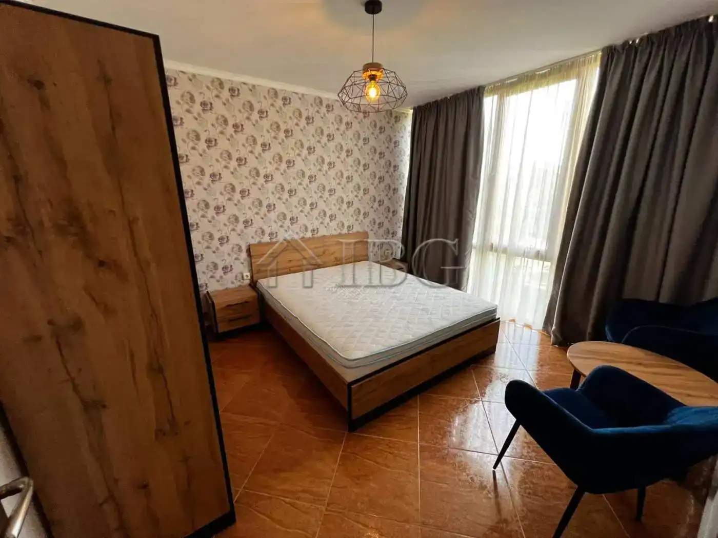 Modern bedroom with large window and stylish decor for comfortable living.