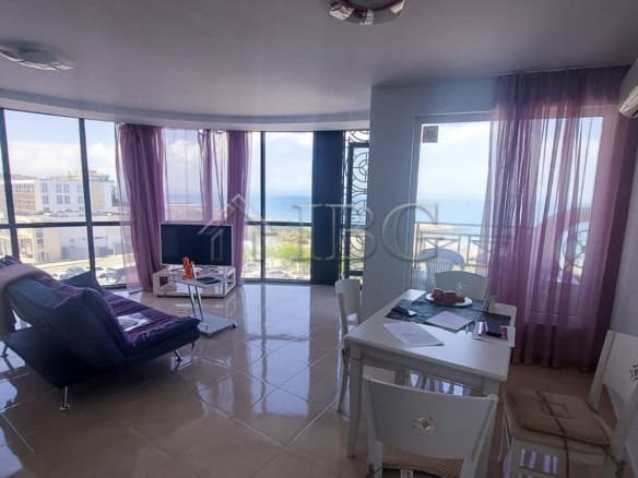 Bright living room with sea views and large windows, featuring a cozy sofa, dining area, and modern.