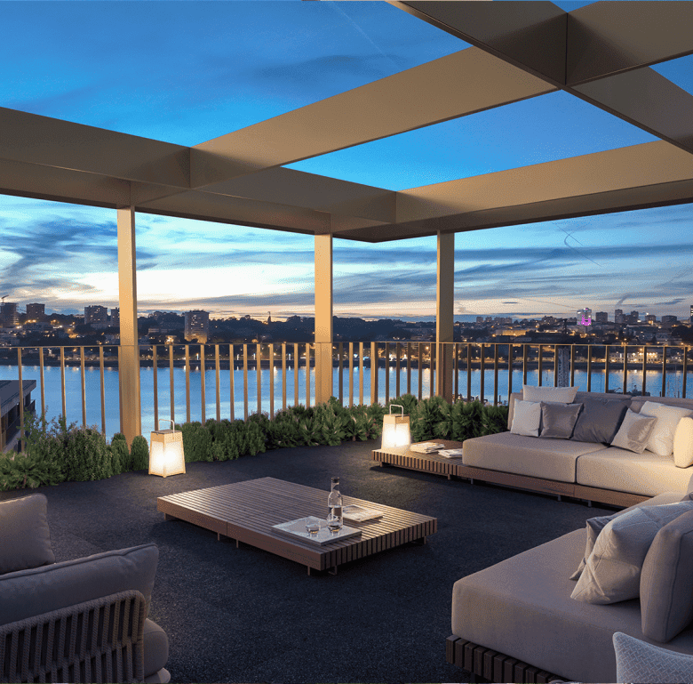 Rooftop terrace in Porto, Portugal, with modern outdoor furniture and panoramic city views at sunset.