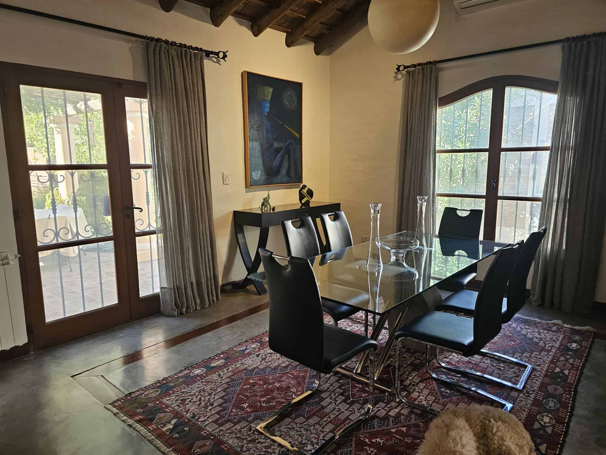 Modern dining room with large windows and elegant decor for stylish living. Spacious dining area with glass table, black chairs, and natural light from large windows.