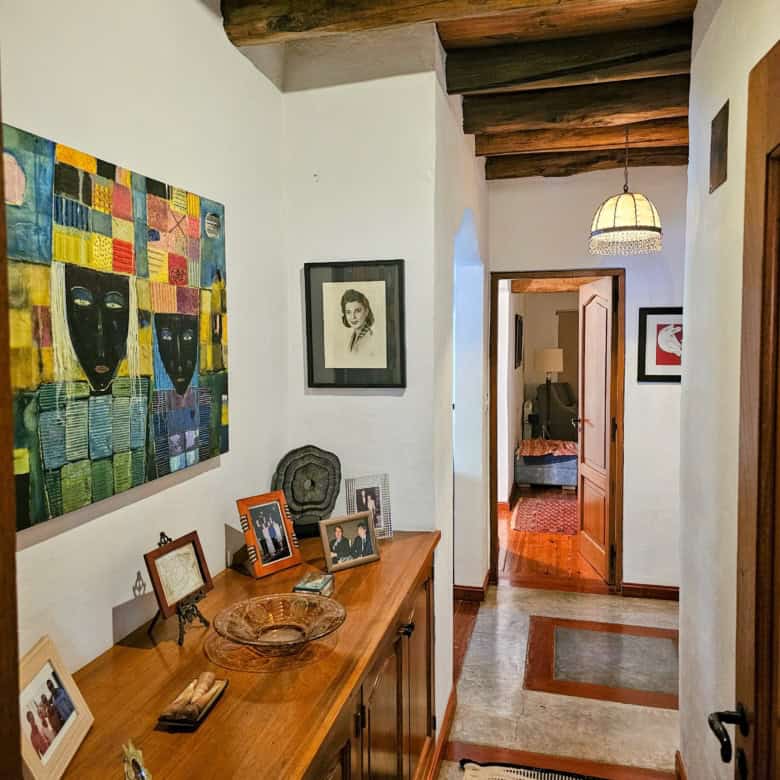 Interior hallway with wooden ceiling beams and artwork.