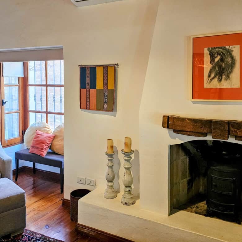 Cozy living room featuring a fireplace, colorful artwork, and comfortable seating in a bright, invit.