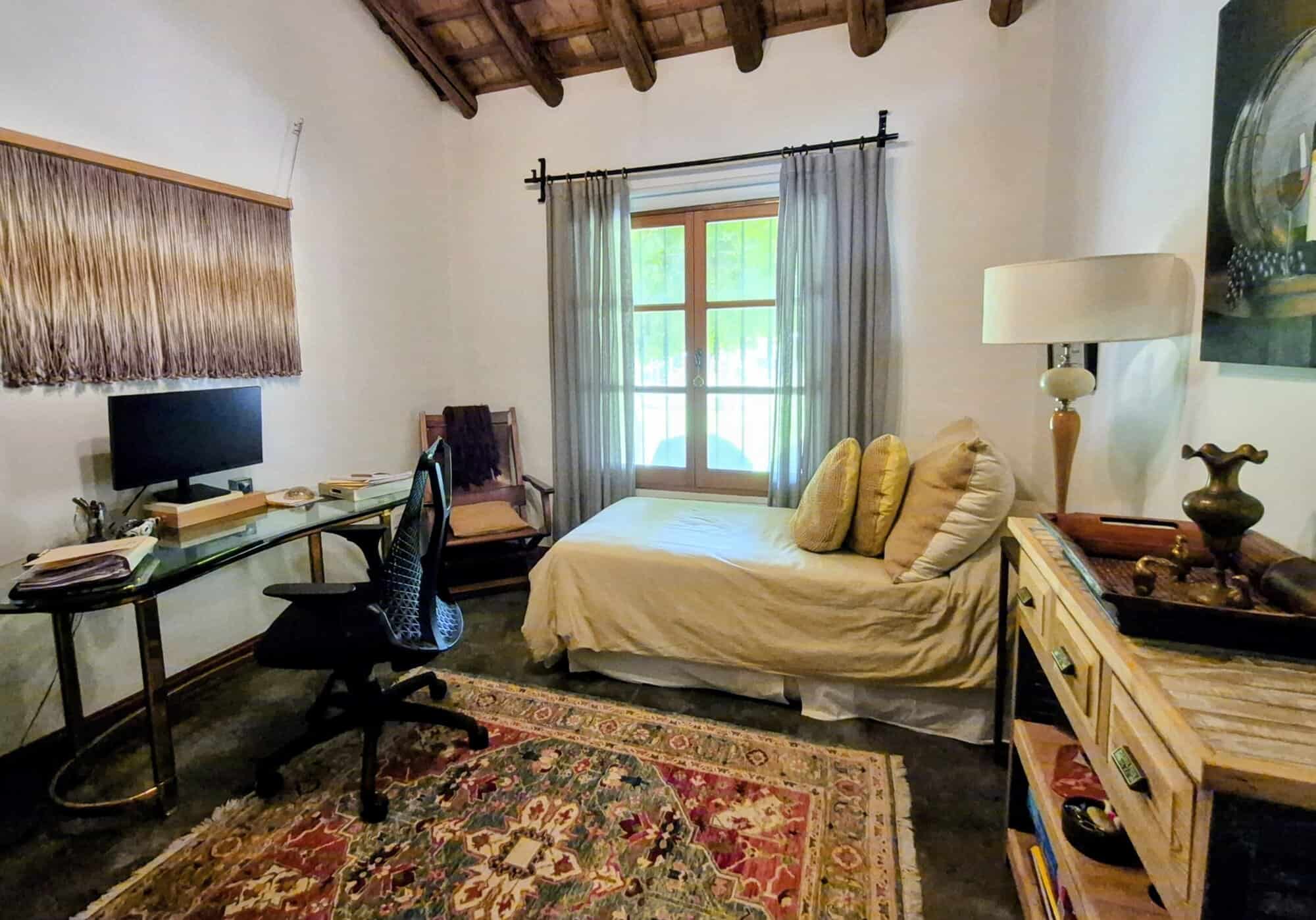 Cozy Rustic Bedroom with Vintage Decor Comfortable bedroom with rustic charm, featuring a daybed, wooden furniture, and natural light from.