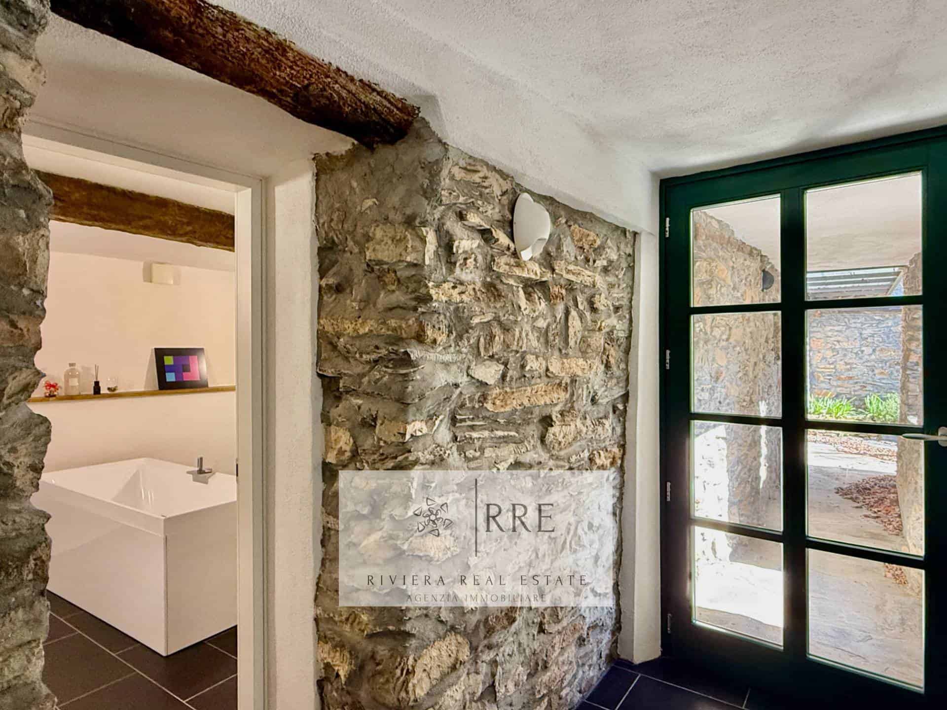 Stone wall with glass door for stylish home entry.