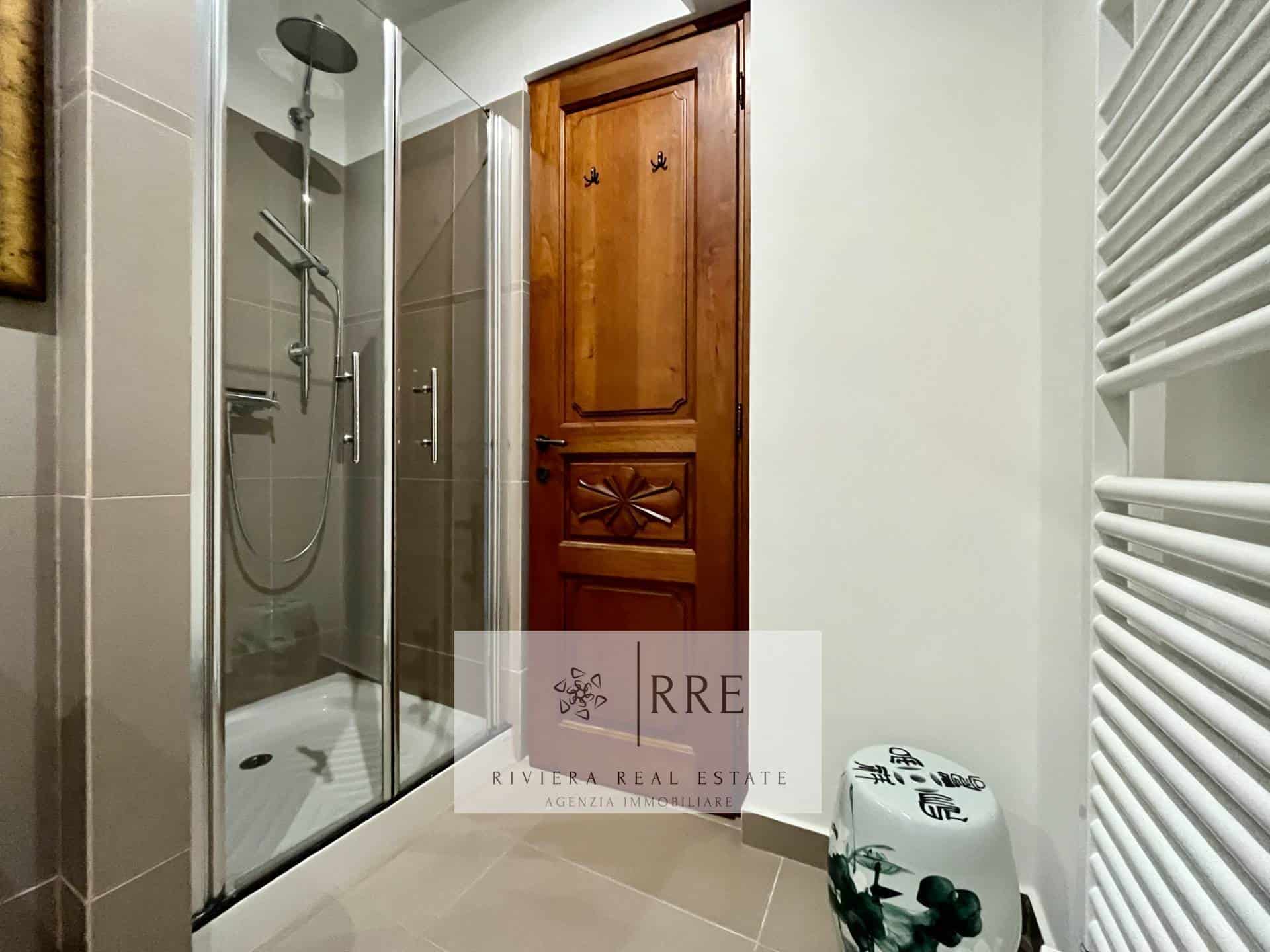 Bathroom with glass shower and wooden door for a stylish home.