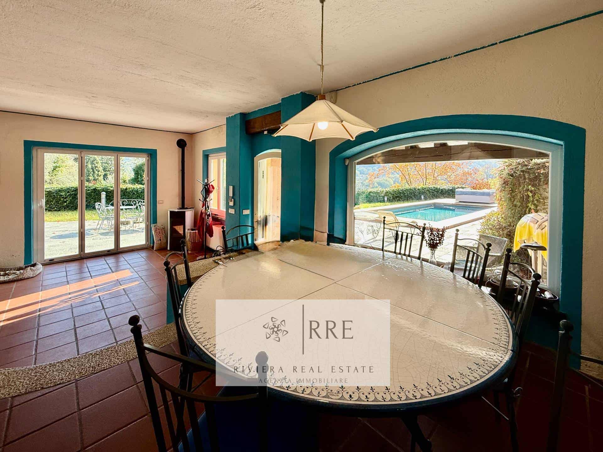 Indoor dining room with large windows overlooking the pool and garden.