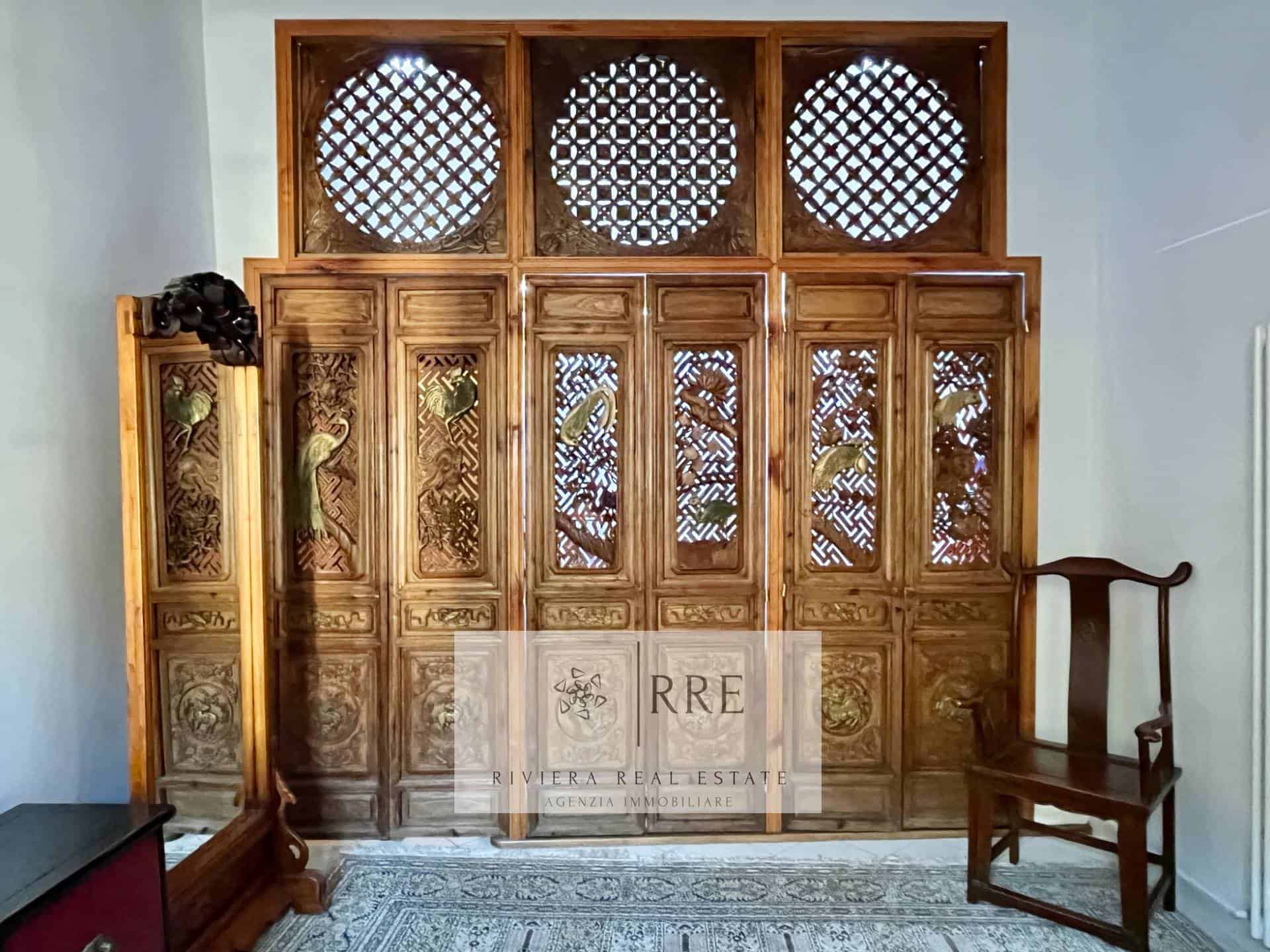 Traditional wooden lattice window with intricate carvings and circular design elements.