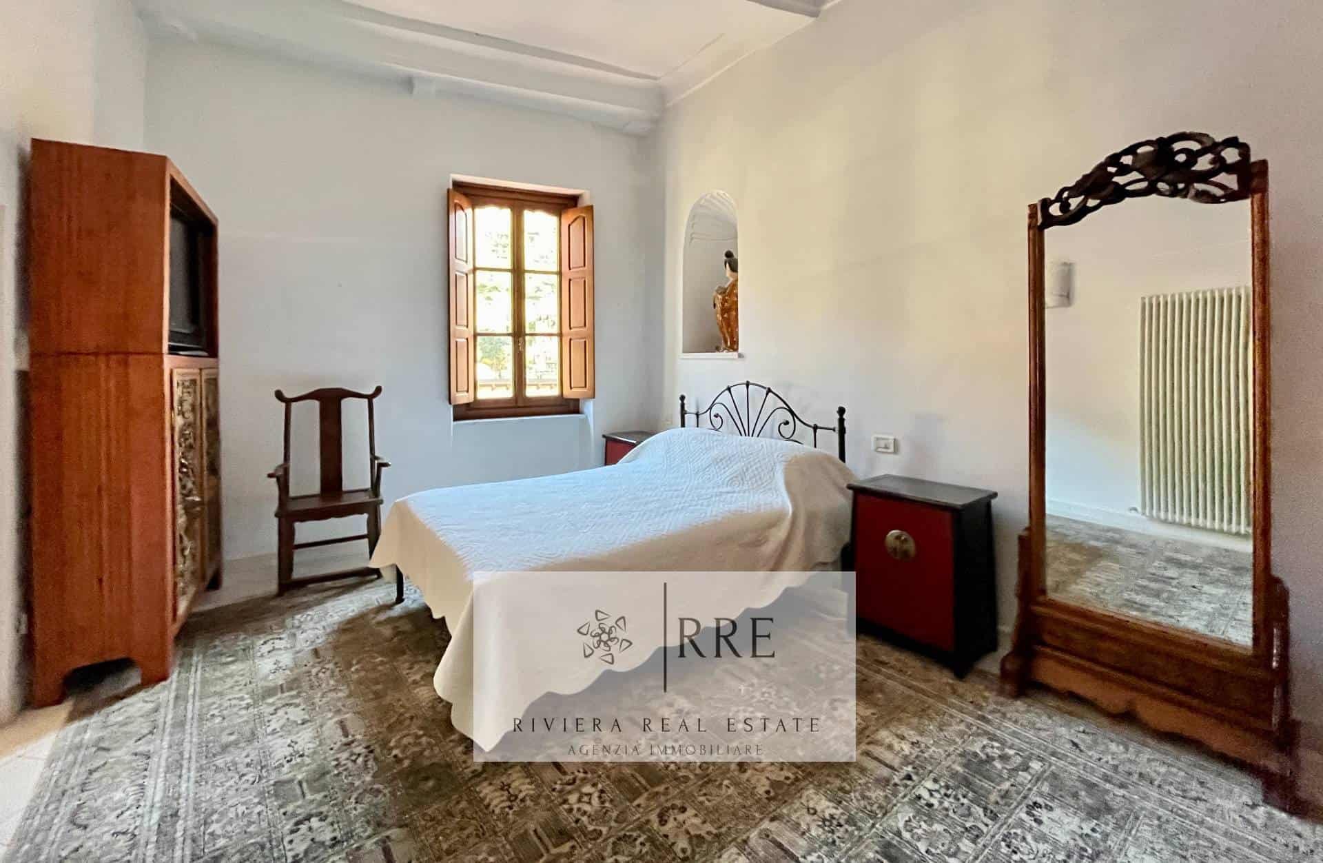 Vintage bedroom with wooden furniture and large mirror.