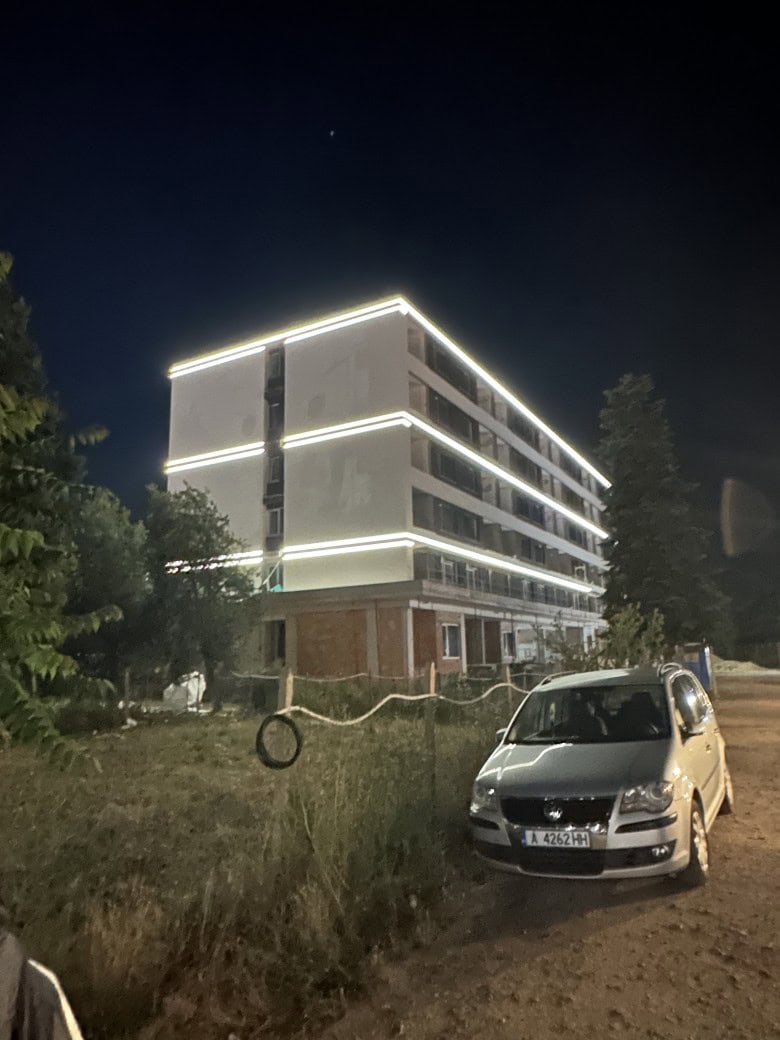 Modern illuminated apartment building at night in Sunny Beach Brightly lit luxury apartment complex with sleek design and pool in Sunny Beach at night.