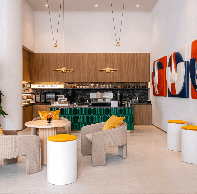 Bright interior of a Bangkok cafe featuring contemporary art, comfortable chairs, and a stylish coff.