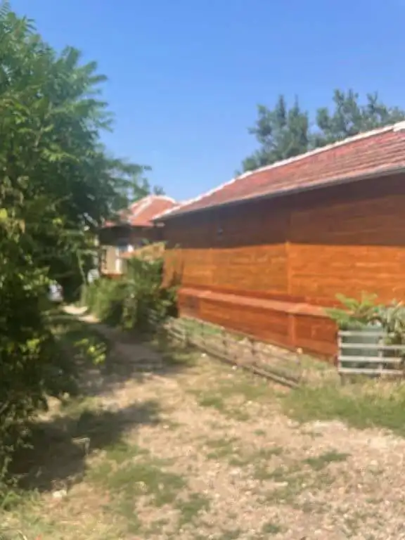 Traditional wooden country house in Traykovo, Lom Bulgaria with lush greenery.