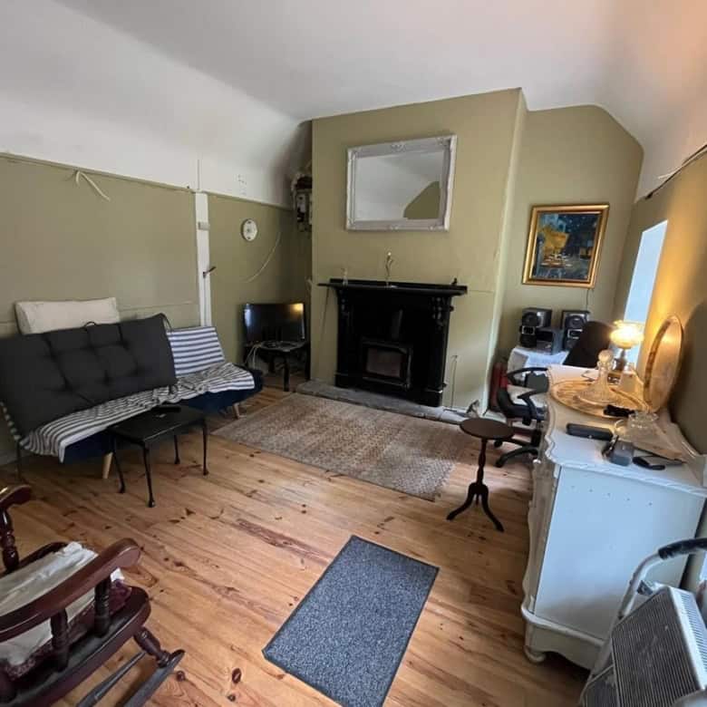 Charming interior of a traditional Irish cottage with vintage furniture and a fireplace.