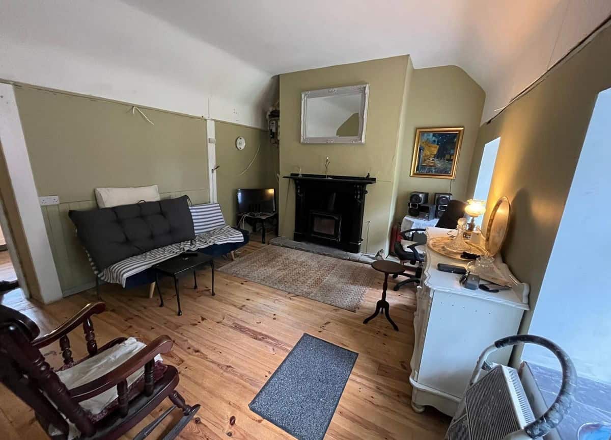 Charming interior of a traditional Irish cottage with vintage furniture and a fireplace.