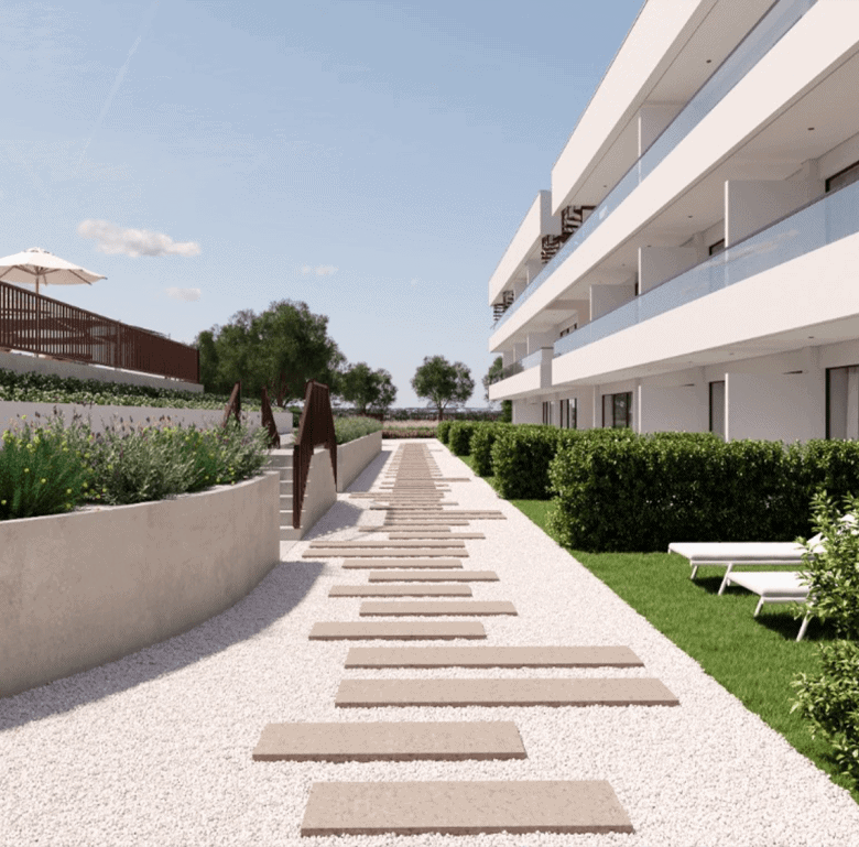 Modern Algarve apartment complex with landscaped gardens and outdoor seating.