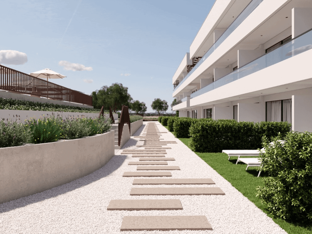 Modern Algarve apartment complex with landscaped gardens and outdoor seating.