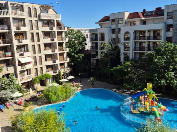 Apartment complex with swimming pool and lush greenery in Sunny Beach, Bulgaria.