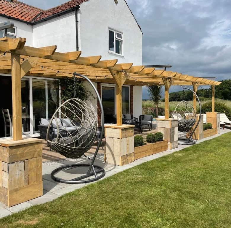Beautiful outdoor patio featuring hanging egg chairs and a wooden pergola for relaxing and entertain.