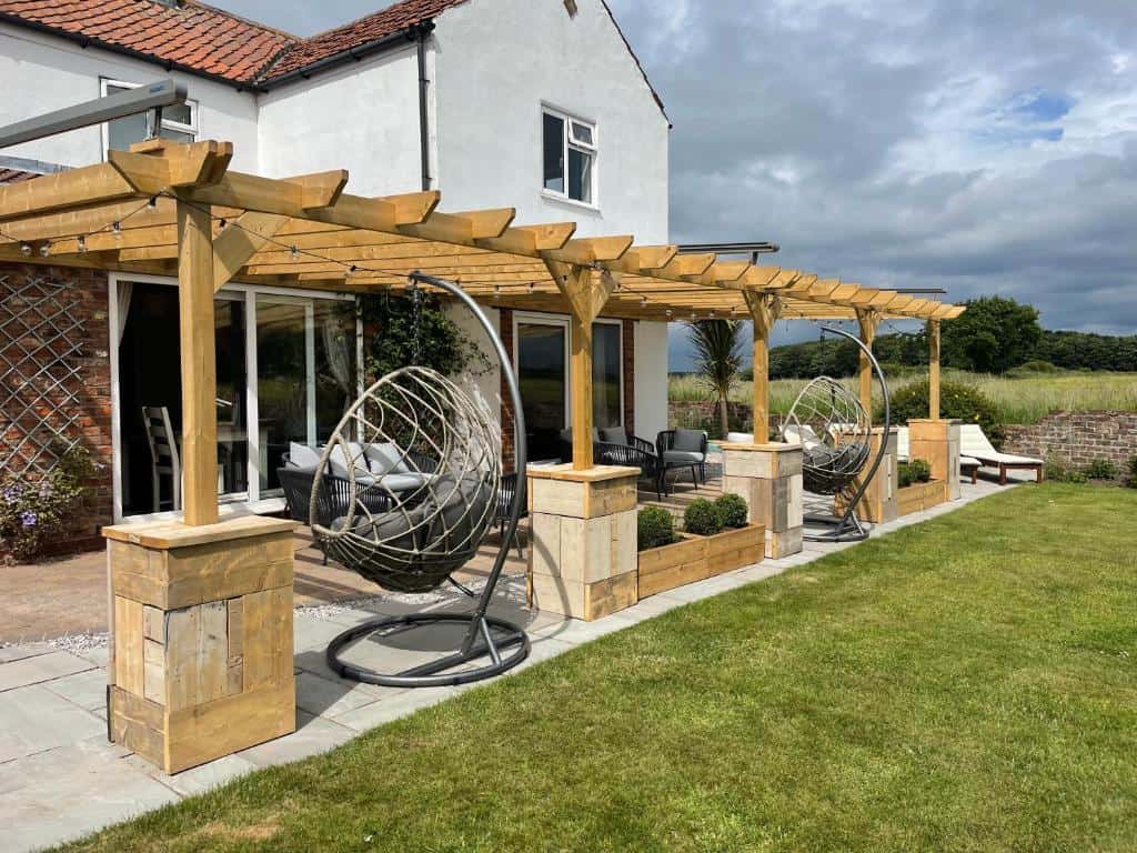 Charming outdoor patio with hanging egg chairs and pergola Beautiful outdoor patio featuring hanging egg chairs and a wooden pergola for relaxing and entertain.