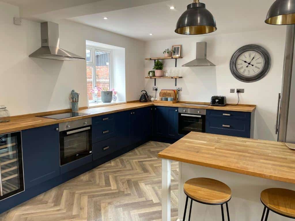 Modern kitchen with navy blue cabinets and wooden countertops Modern kitchen with navy blue cabinets, wooden countertops, and stainless steel appliances.