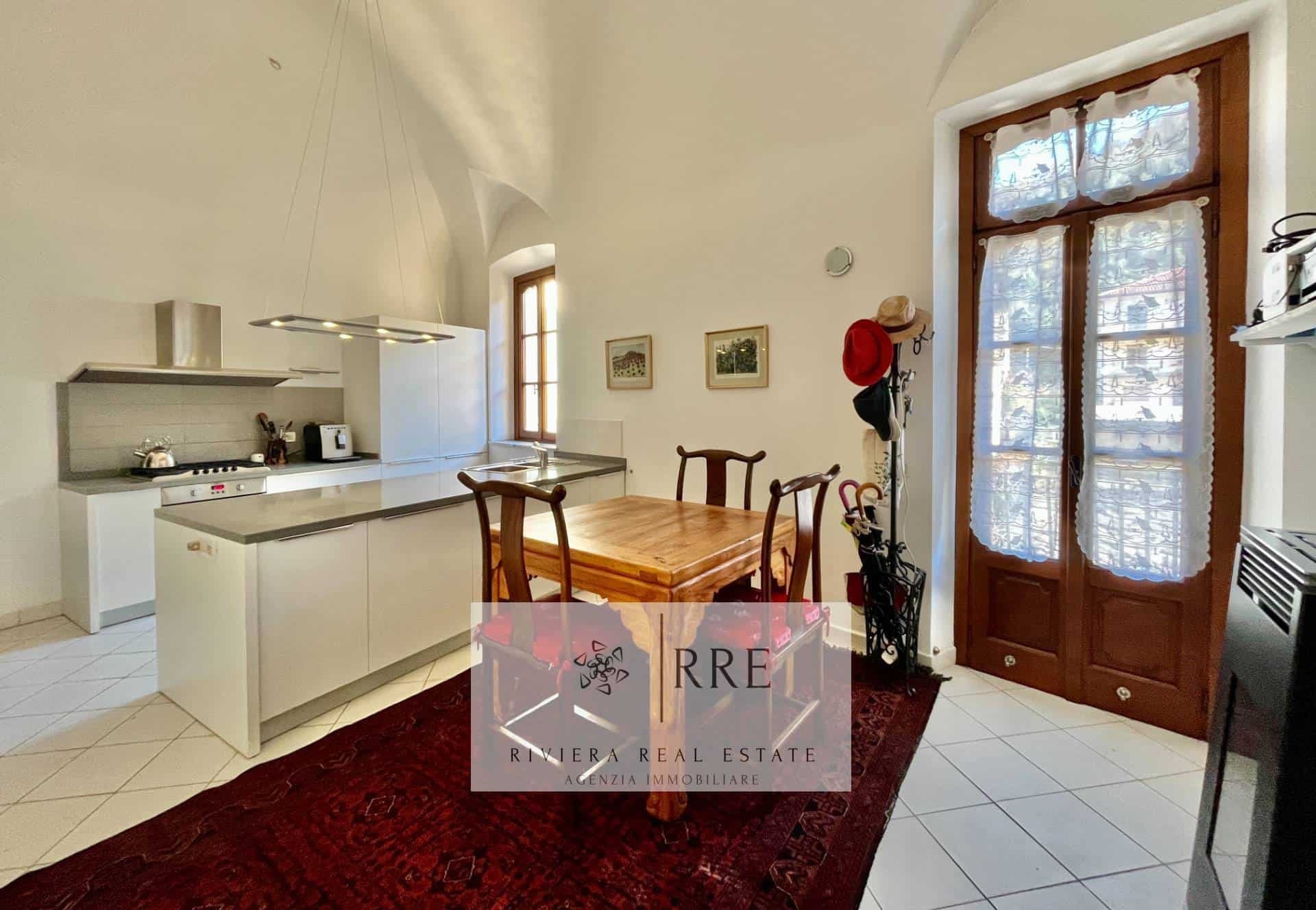 Bright kitchen with large windows and wooden dining table.