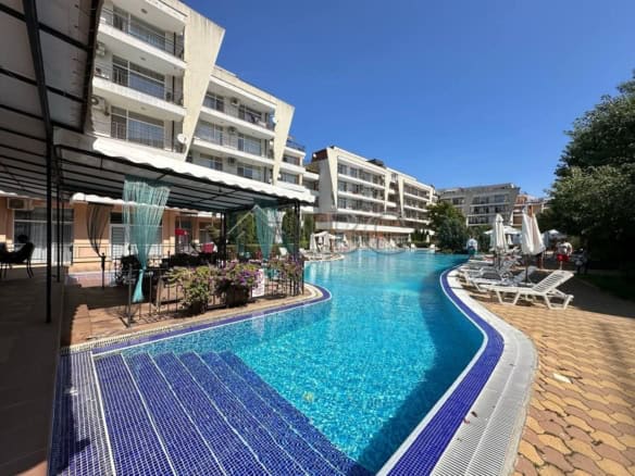 Apartment complex with outdoor pool and sun loungers in Sunny Beach, Bulgaria.