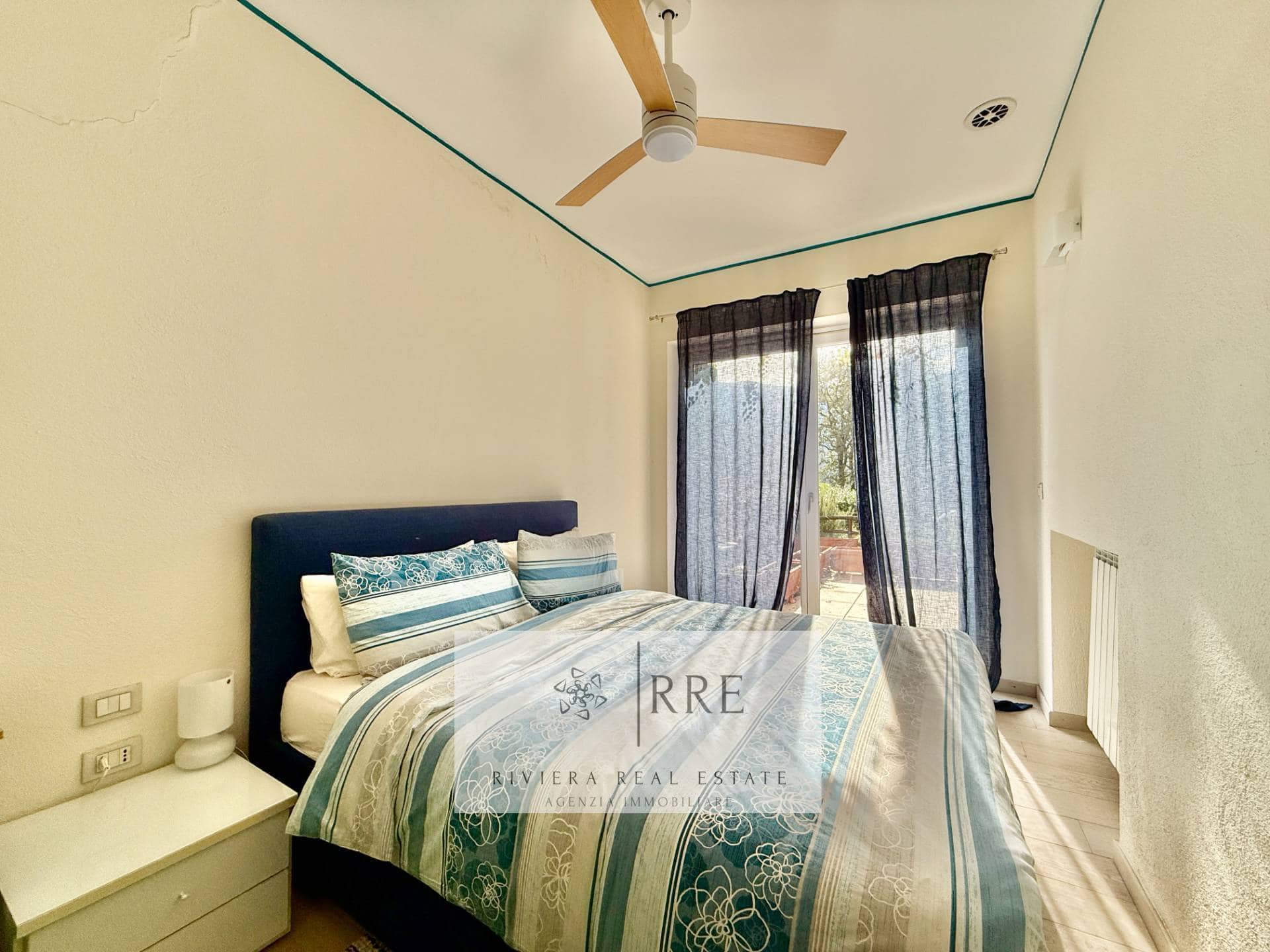 Spacious bedroom with large windows, curtains, and contemporary decor for a comfortable stay.