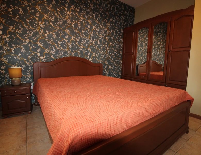 Apartment with double bed and wooden furniture near the sea.