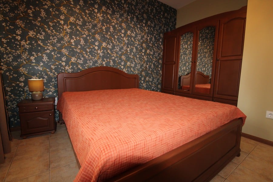Apartment with double bed and wooden furniture near the sea.
