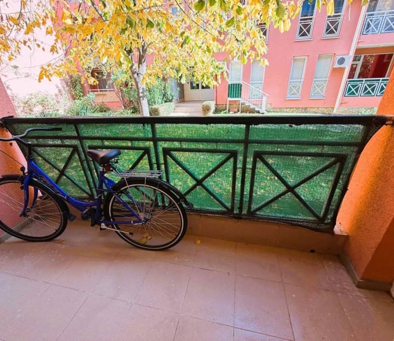 Bright balcony with garden view and bicycle parking.