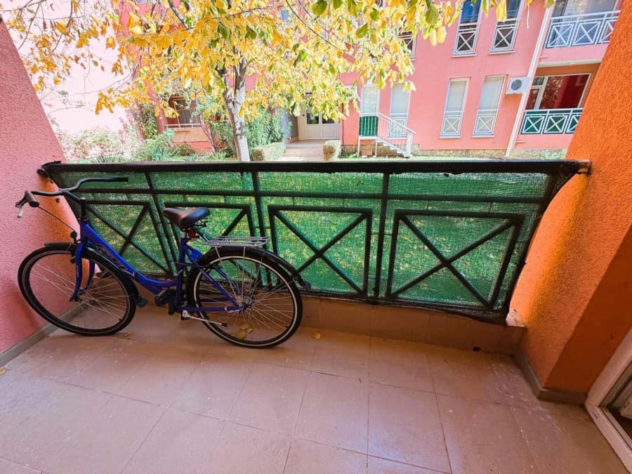 Bright balcony with garden view and bicycle parking.