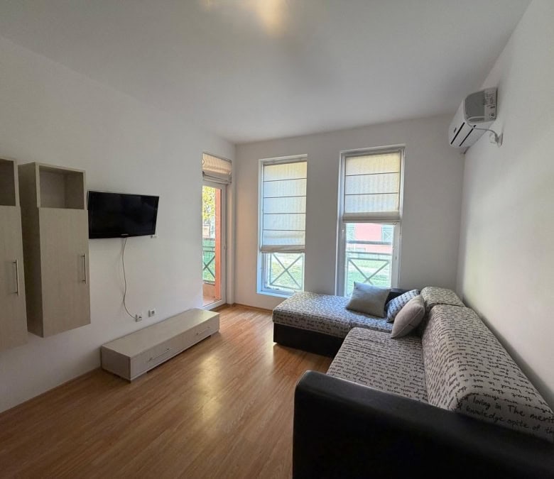Bright 2-bedroom apartment with living area, sofa, and balcony near Sunny Beach, Bulgaria.