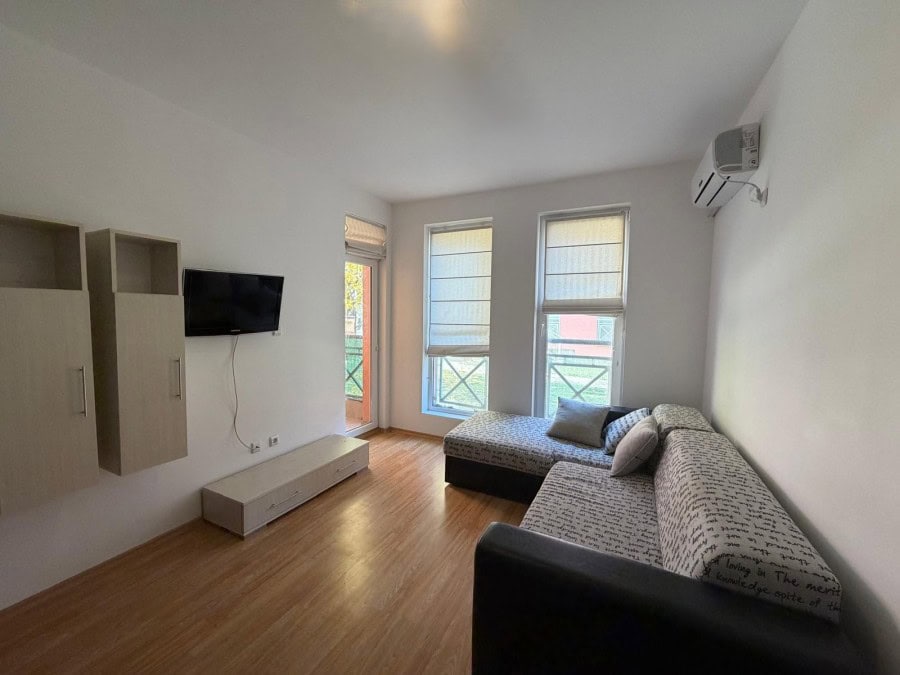 Bright 2-bedroom apartment with living area, sofa, and balcony near Sunny Beach, Bulgaria.