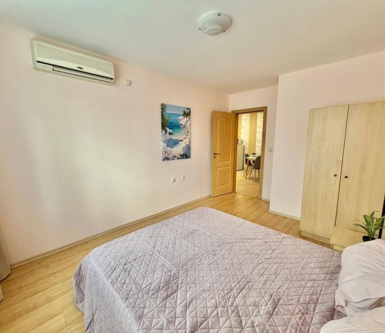 Bright 2-bedroom apartment in Sveti Vlas with mountain views, near the sea, featuring a spacious bed.