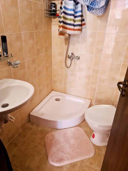 Furnished bathroom with shower, toilet, and sink in a compact apartment near Sunny Beach.