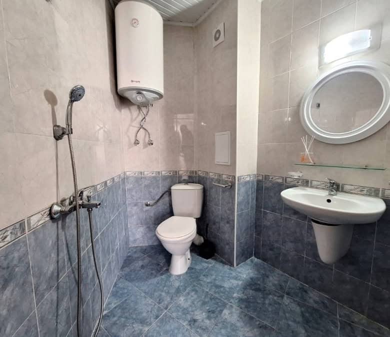 Bathroom with shower, toilet, and sink in a newly furnished apartment.