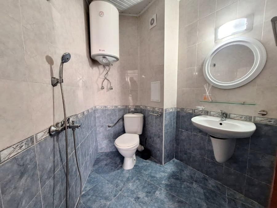 Bathroom with shower, toilet, and sink in a newly furnished apartment.