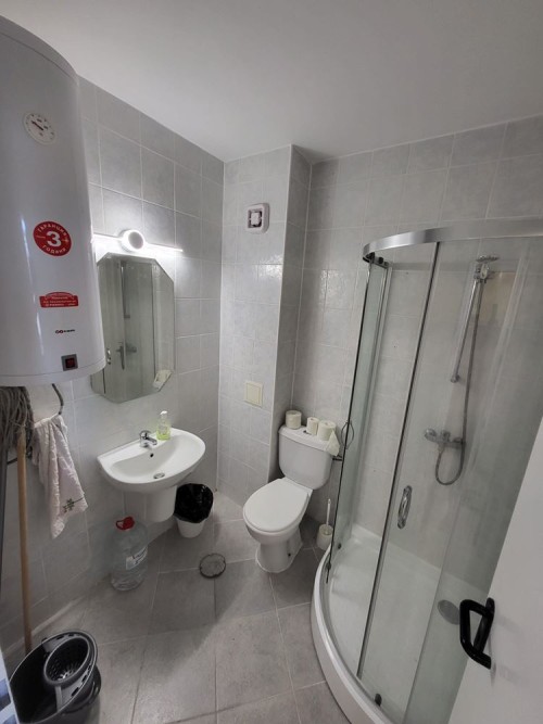 Bright bathroom with shower, toilet, and sink in Sunset Kosharitsa.