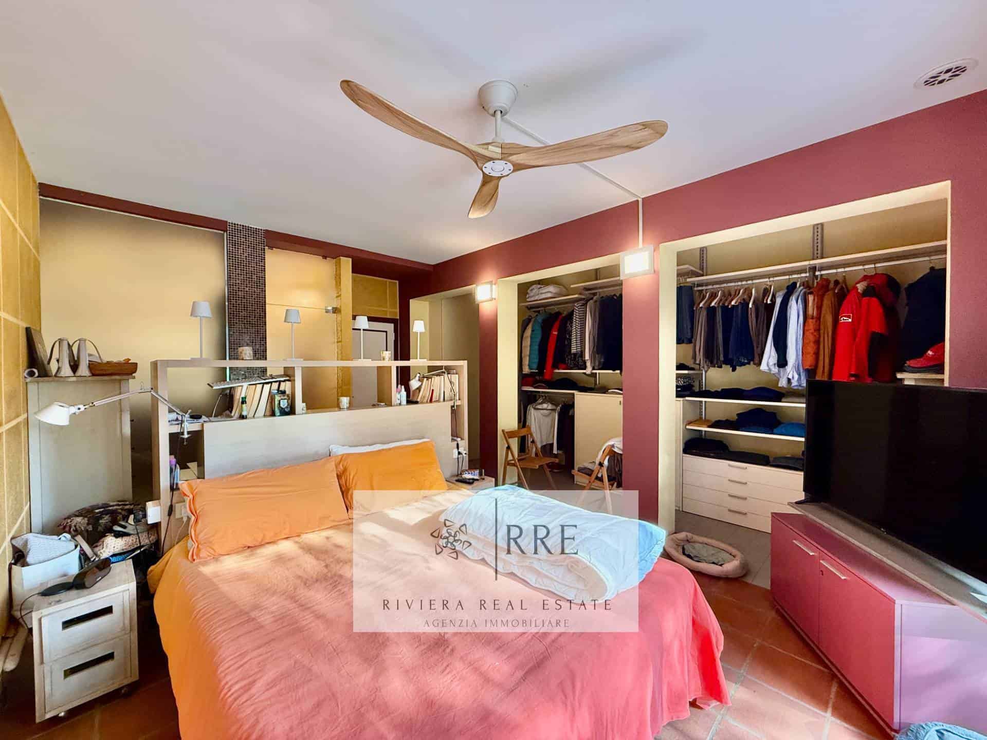 Modern bedroom with open closet and ceiling fan for comfortable living.
