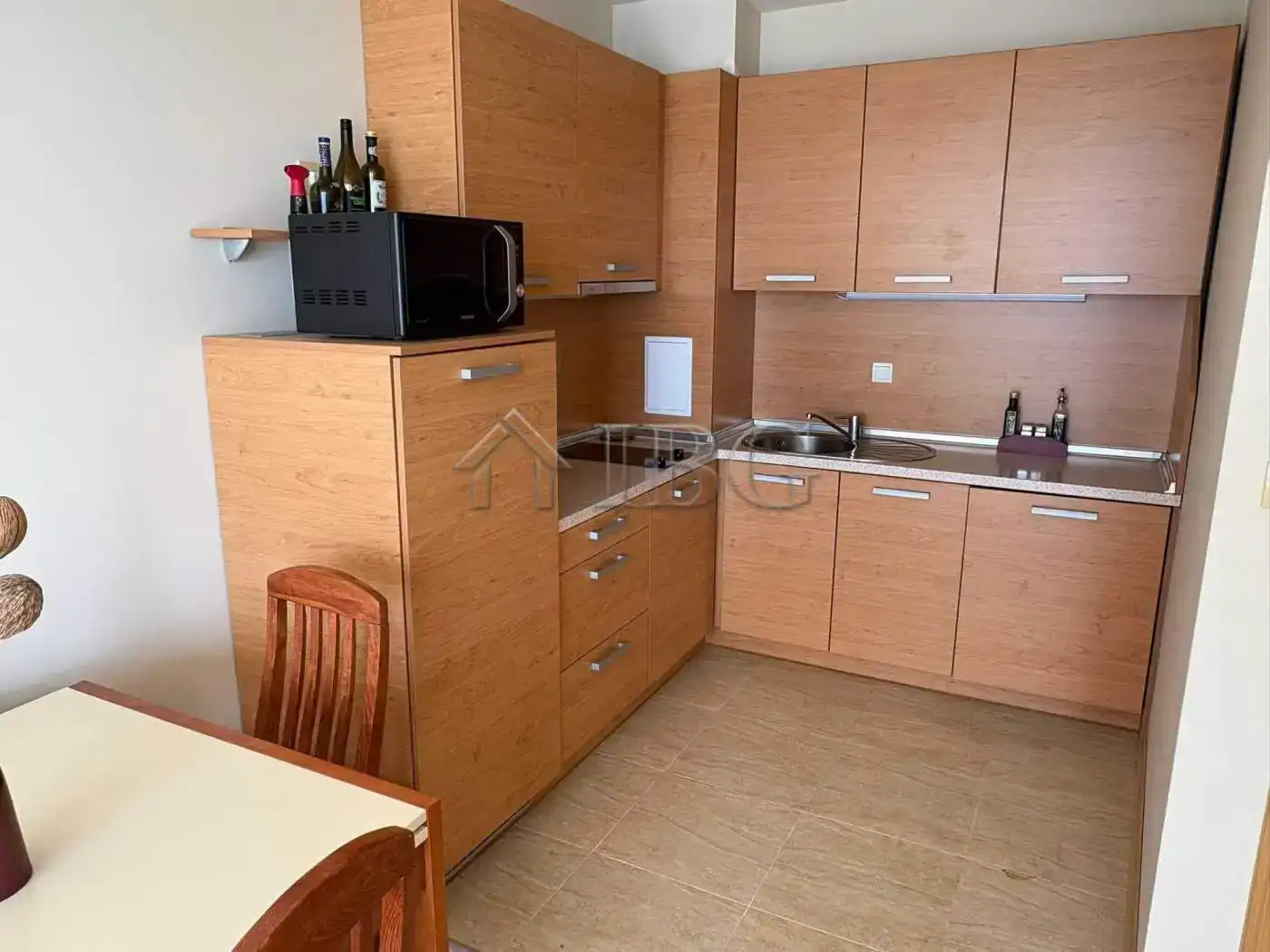 Modern wooden kitchen with compact design and essential appliances.