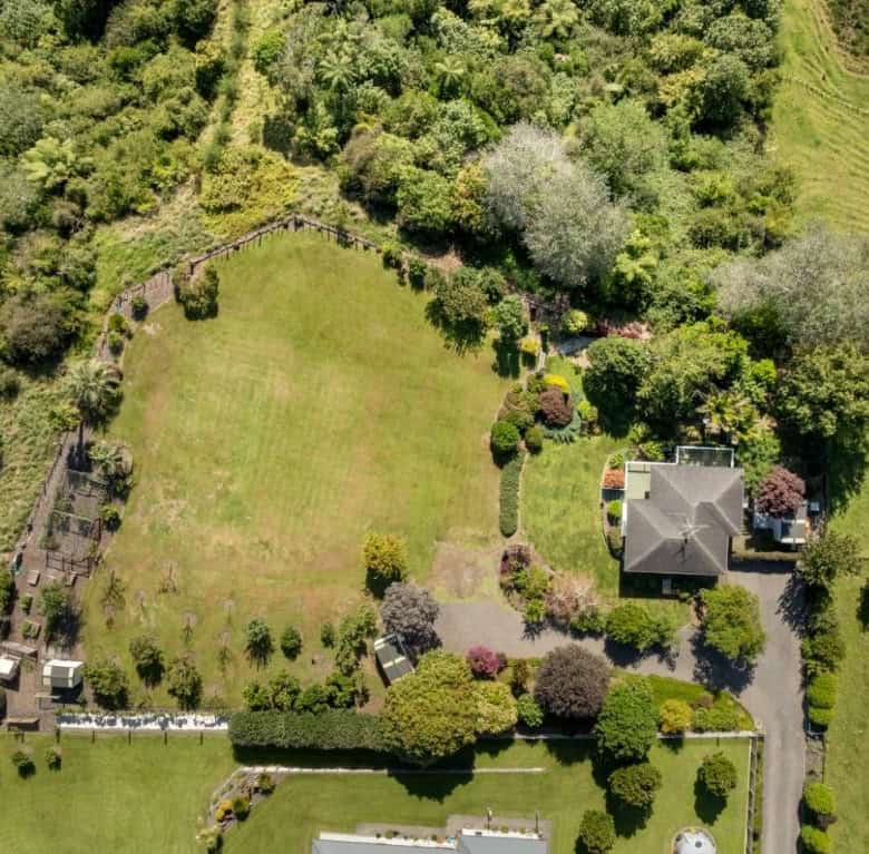 Aerial view of a beautiful cottage estate with lush gardens and spacious lawn in Tauranga, Bay of Pl.