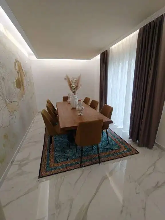 Elegant dining room in Bernalda Italy with modern decor and natural light.