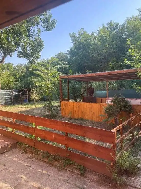 Country house for sale in Traykovo, Lom Bulgaria with lush garden and outdoor seating area.