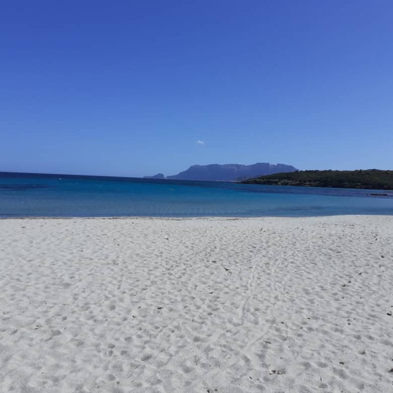 Beach in Sardinia with clear blue sky and calm sea, near Calangianus.