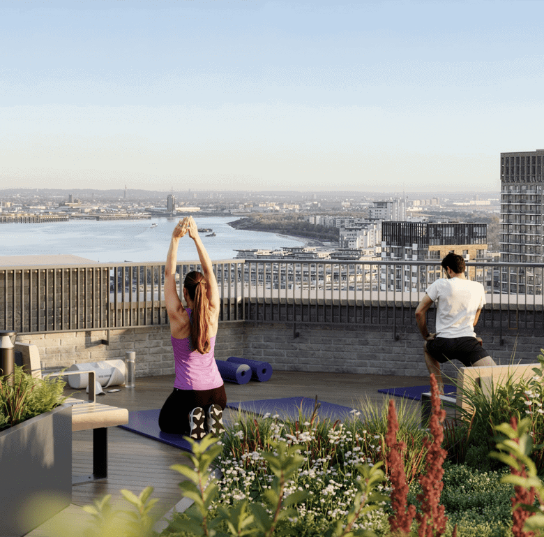 Rooftop yoga session overlooking Woolwich Tower and the Thames River in London, UK.