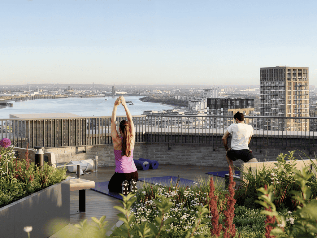 Rooftop yoga session overlooking Woolwich Tower and the Thames River in London, UK.