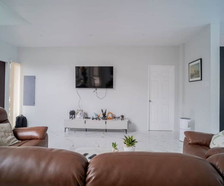 Spacious living room featuring a flat-screen TV, modern furniture, and bright, airy design.