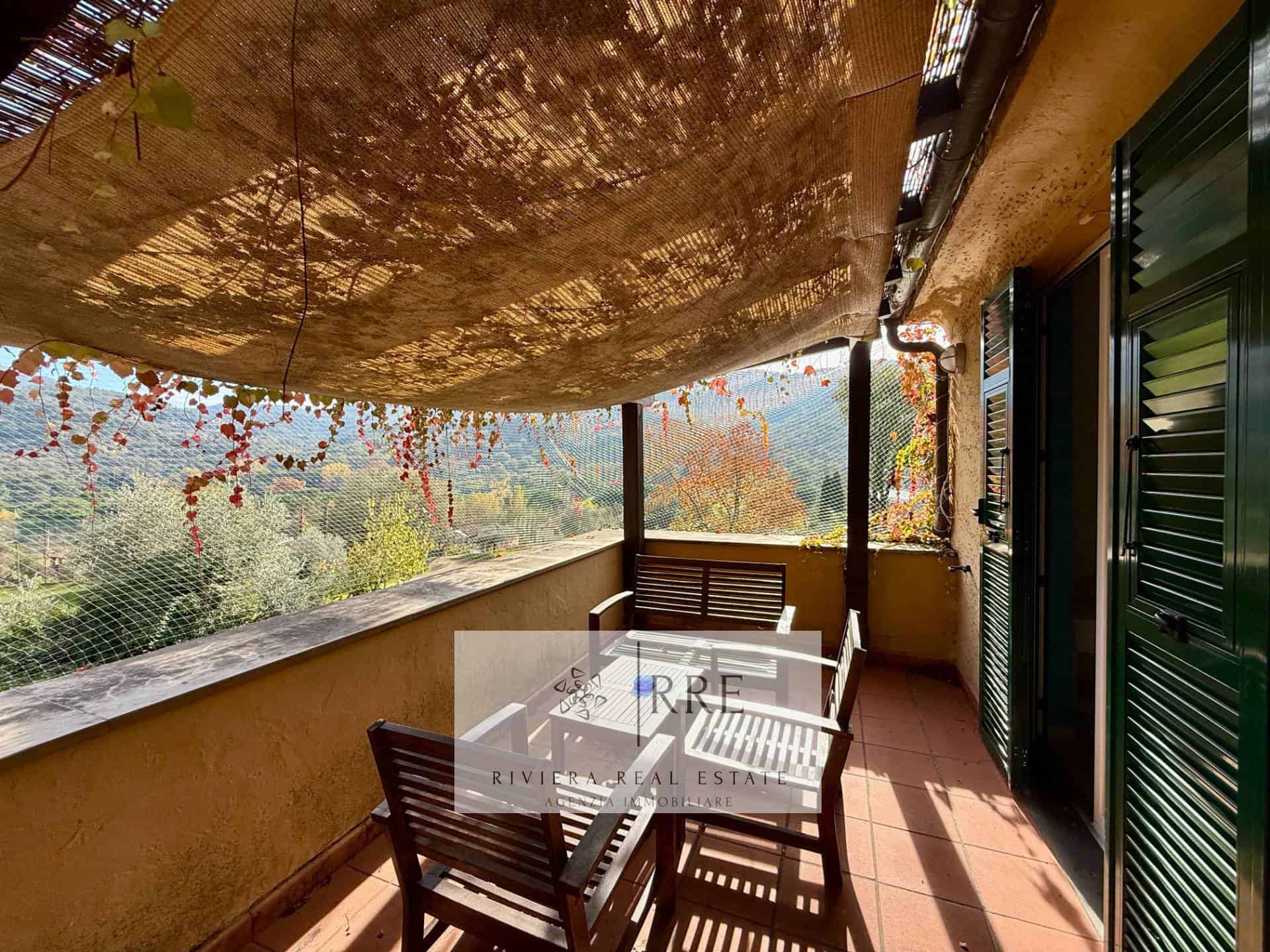 Balcony overlooking lush landscape with outdoor seating and shade canopy. Perfect for relaxing and e.