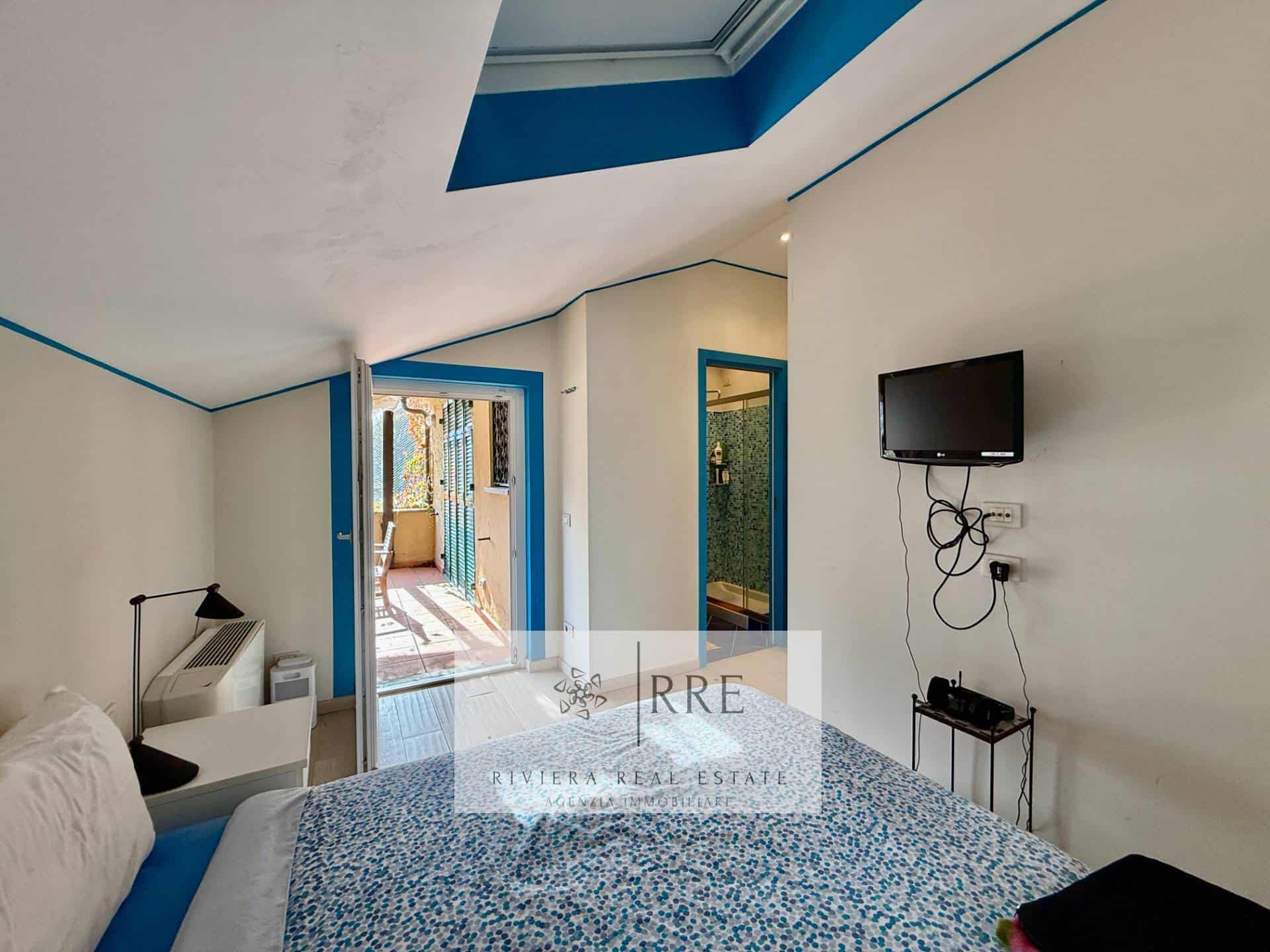 Spacious bedroom featuring blue accents, a balcony, and modern decor for a comfortable stay.