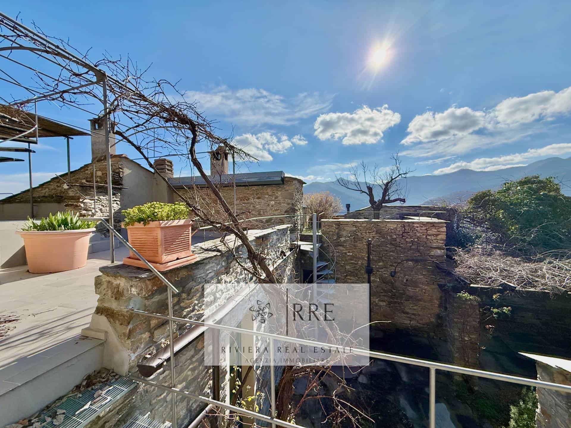 Rustic terrace with mountain views and outdoor seating in a historic property.